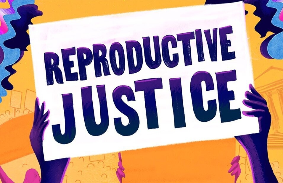 Two hands holding up a sign reading 'Reproductive Justice'. There is a colorful background behind the poster.